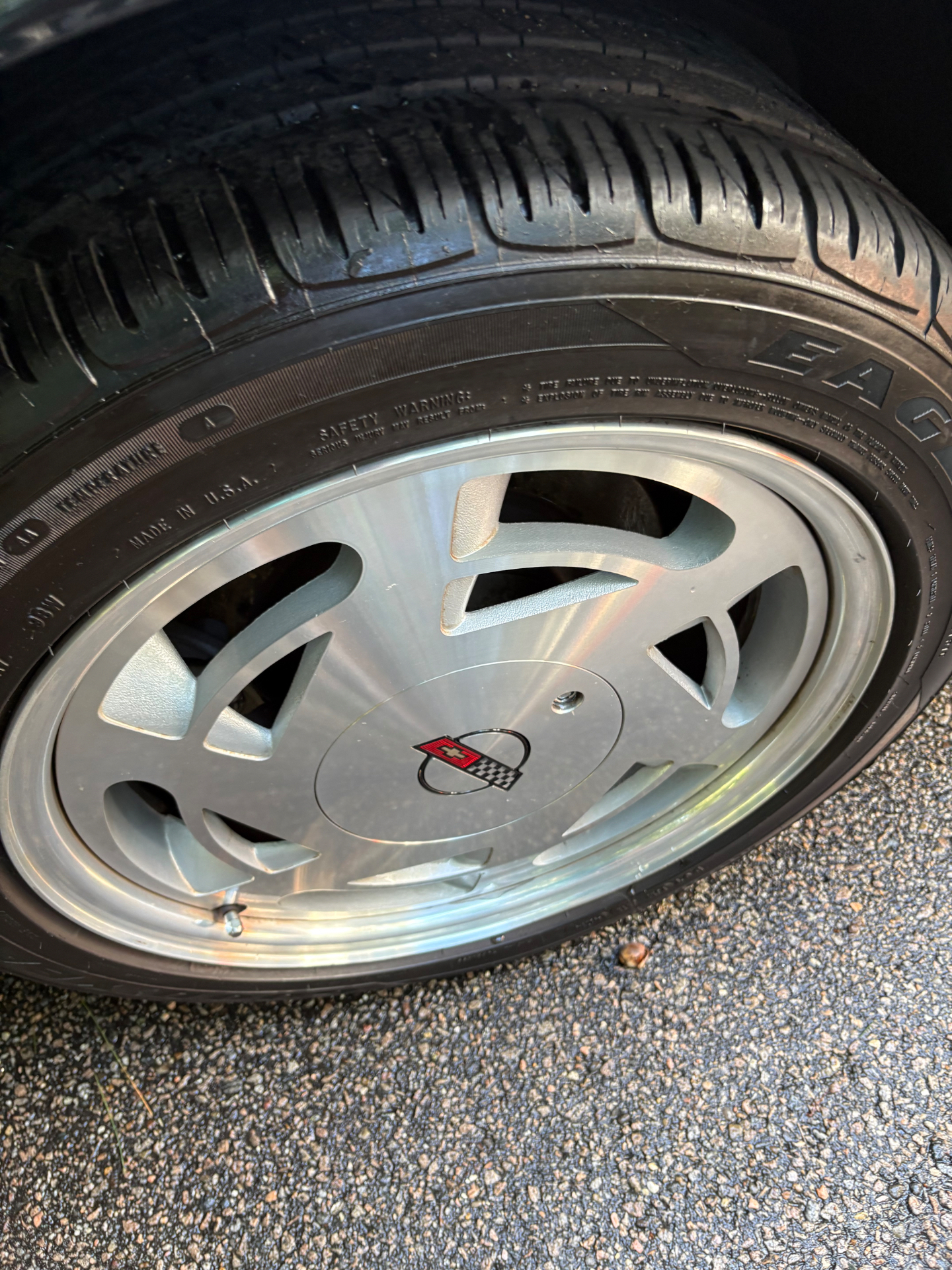 Polished Corvette alloy wheel with a clean tire and detailed center cap